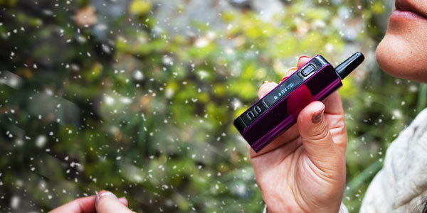 Woman holding Exxus Snap VV Pro in front of park trail with snow falling