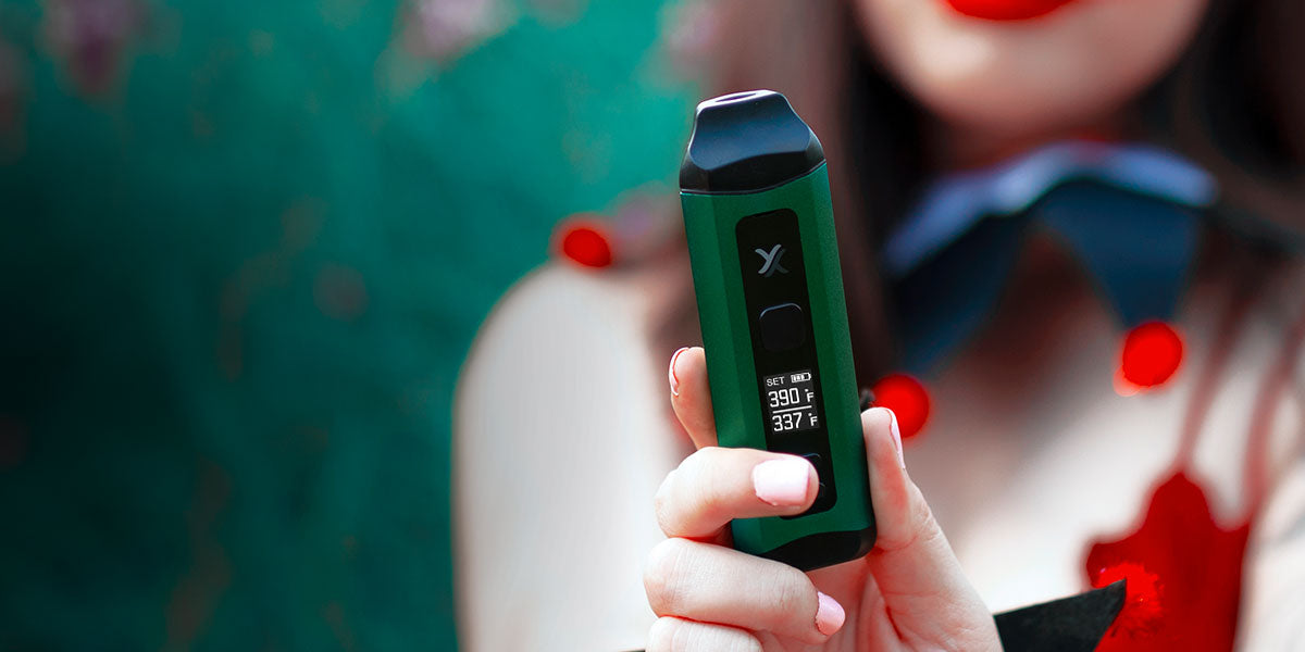 Person in cloud costume holding a green Exxus Mini Plus with a blurred background